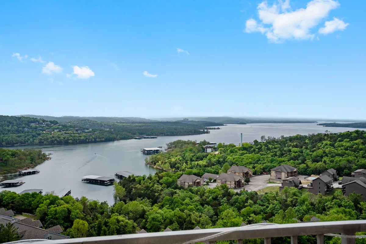 A serene view of Table Rock Lake, with calm waters, lush green surroundings, and distant hills under a vast sky. The image evokes relaxation, scenic beauty, and opportunities for lakeside activities.